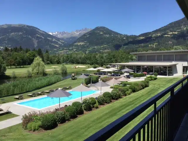 Blick auf den Golfplatz und Pool im Golfhotel Dolomitengolf Lavant
